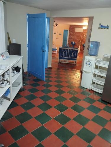 a kitchen with a checkered floor and a blue door at Beachfront Serenity Villa with Pool, AC, 1 min from the the beach, Jacuzzi, Wifi in Sabana Grande de Palenque