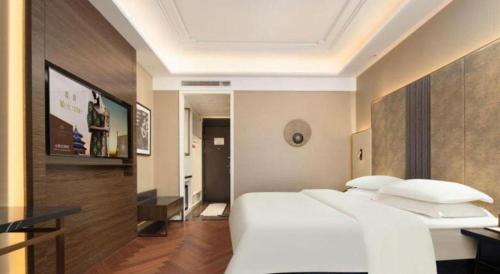 a bedroom with a large white bed in a room at Jinjiang Metropolo Hotel - Taizhou Wanda Plaza in Taizhou