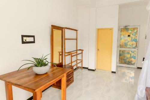 a room with a wooden table with a potted plant on it at Ominiyet Villa in Galle