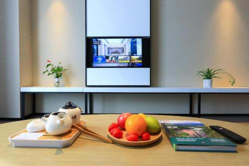 a tray of fruit on a table with a tv at GRACE Select Hotel (Kunshan Huaqiao International Convention Center) in Suzhou