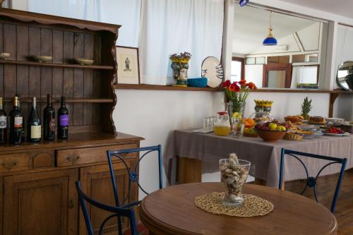 a dining room with a table with bottles of wine at Borgo Marino Plemmirio in Siracusa