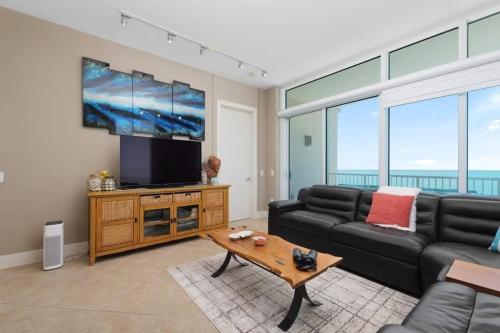 Una sala de estar con un sofá y un televisor de pantalla plana. en Stunning 17th Floor SpaceX Direct Views Luxe apts, en South Padre Island