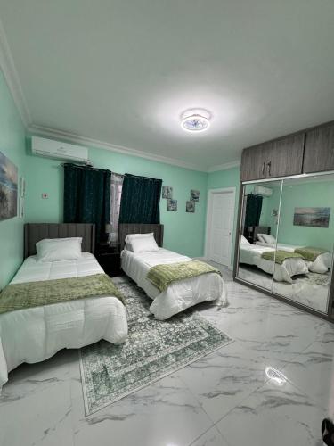 a bedroom with two beds and a large mirror at Luxury Haven- Near AC Marriott Hotel Kingston in Kingston