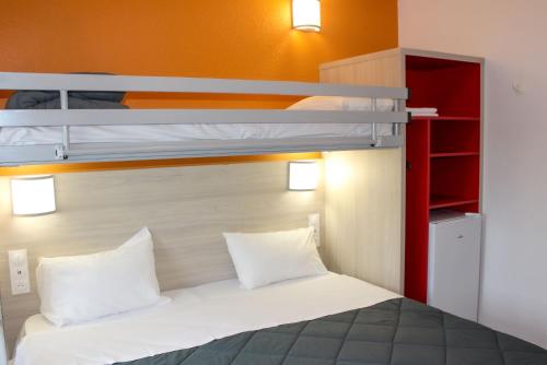 a bedroom with a bunk bed with white pillows at Première Classe Plaisir Gatines in Plaisir