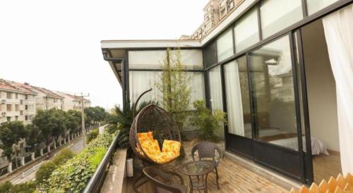 a balcony of a building with a table and chairs at Shell Shanghai Jiading Nanxiang Town Minzhu Street Hotel in Shanghai