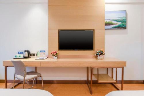 a desk with a television on top of it at GreenTree Inn Weifang Kuiwen District Beiwang Jiale in Weifang