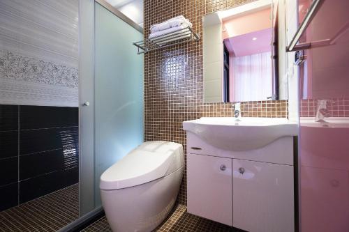 a bathroom with a toilet and a sink and a mirror at Buckingham Palace B&B in Beipu