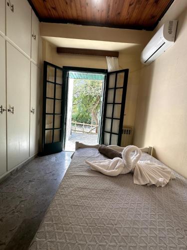 a large bed in a room with a large window at Lyra House in Mikro Metochi
