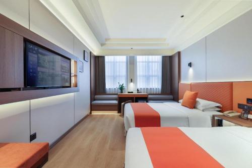 a hotel room with two beds and a flat screen tv at Chengdu Haotian Guotai Hotel in Chengdu