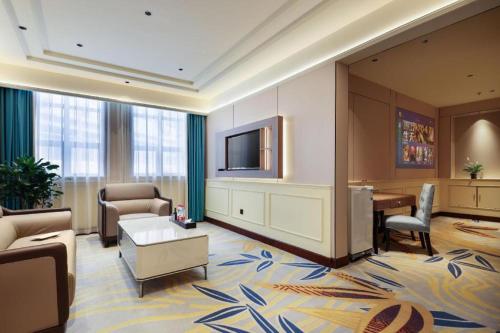 a living room with a couch and a television in a room at Chengdu Haotian Guotai Hotel in Chengdu