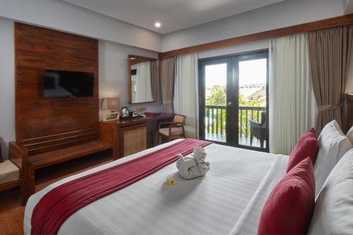 a hotel room with a bed with a stuffed animal on it at The Lokha Legian Resort & Spa in Legian