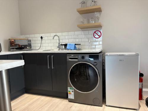 una cocina con lavadora y fregadero en Metanoia Kingswood Golf Estate, en George