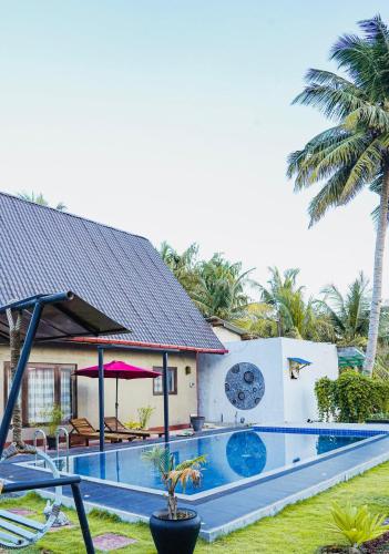 a house with a swimming pool in front of a house at Ramya Ru Nature Resort in Galle