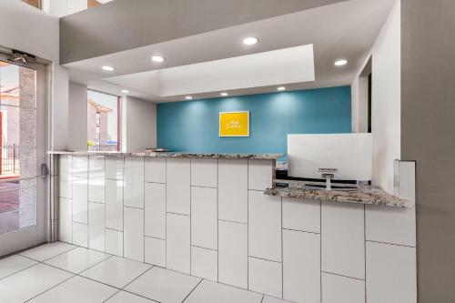 a lobby with a blue wall and a reception counter at Days Inn by Wyndham Phoenix West in Phoenix