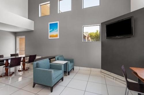 a dining room with a table and a tv at Days Inn by Wyndham Phoenix West in Phoenix