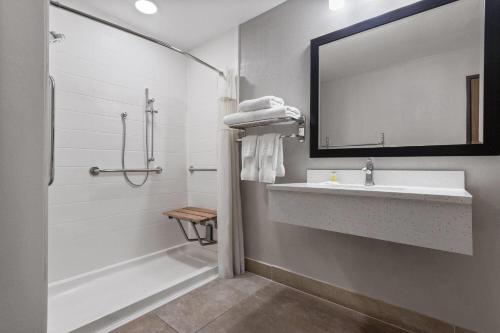 a bathroom with a sink and a tub and a mirror at Days Inn by Wyndham Phoenix West in Phoenix