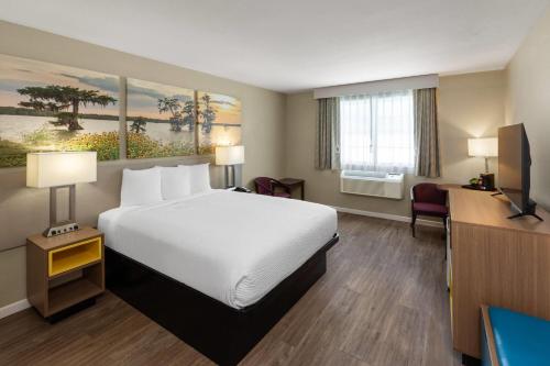 a hotel room with a bed and a desk at Days Inn by Wyndham Mountain Home in Mountain Home