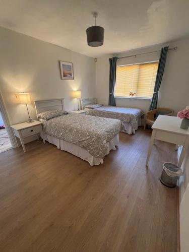 ein Schlafzimmer mit 2 Betten und einem Tisch mit 2 Lampen in der Unterkunft Luxury stylish Kincora Townhouse in Killaloe