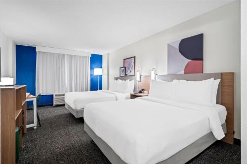a hotel room with two beds and a television at Spark by Hilton Orlando near Universal in Orlando