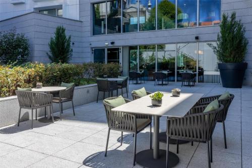 a patio with tables and chairs in front of a building at Cenica Porto Hotel, Curio Collection By Hilton in Porto