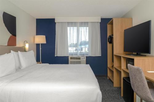 a hotel room with a bed and a flat screen tv at Spark by Hilton Carlisle South in Carlisle