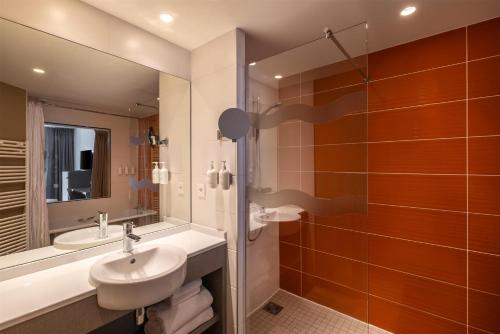 a bathroom with a sink and a toilet and a shower at Spark by Hilton Lyon Park Saone in Lyon