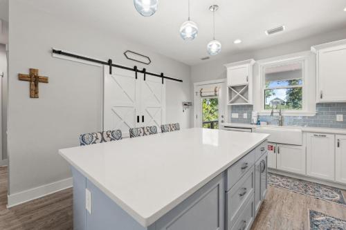 a kitchen with a white counter and a cross on the wall at Fruitcakes- Private Pool- Hot Tub- Pet Friendly in St. George Island