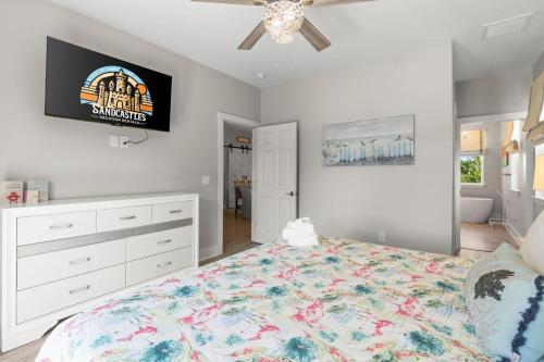 a bedroom with a bed and a tv on the wall at Fruitcakes- Private Pool- Hot Tub- Pet Friendly in St. George Island