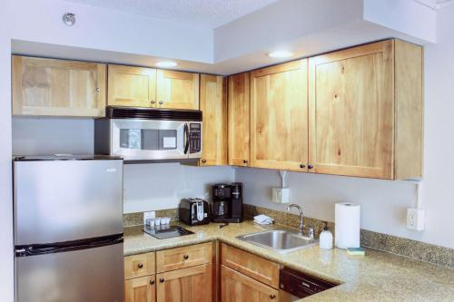 una cucina con mobili in legno e un frigorifero in acciaio inossidabile di 1 Bedroom Condo Perfect Location #303 with Pool and Hot Tub a Mount Crested Butte