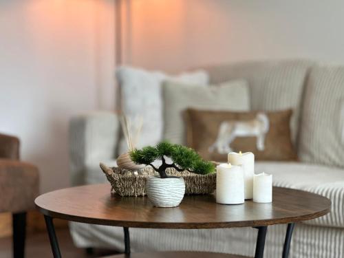 a table with candles and plants on it in a living room at Modern House with four BR two parking bays in Bolton in Bolton
