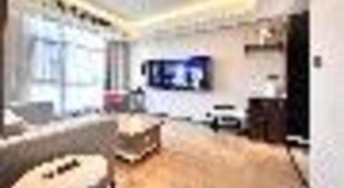a living room with a couch and a tv at Yitel Collection Lianyungang High-speed Railway Station Suning Plaza in Lianyungang