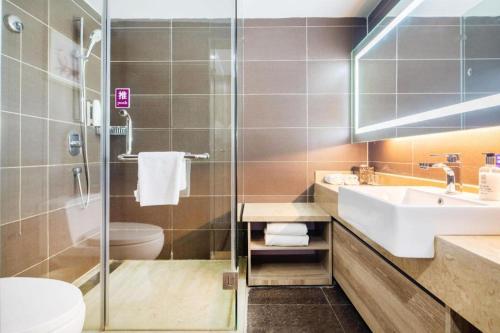 a bathroom with a sink and a toilet and a shower at Yitel Collection Lianyungang High-speed Railway Station Suning Plaza in Lianyungang
