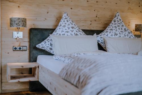 a bedroom with a bed with pillows on it at Chalets am Duschl-Hof in Bayerbach