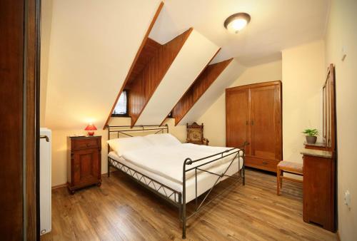a bedroom with a bed and wooden floors at Pension Teddy in Český Krumlov