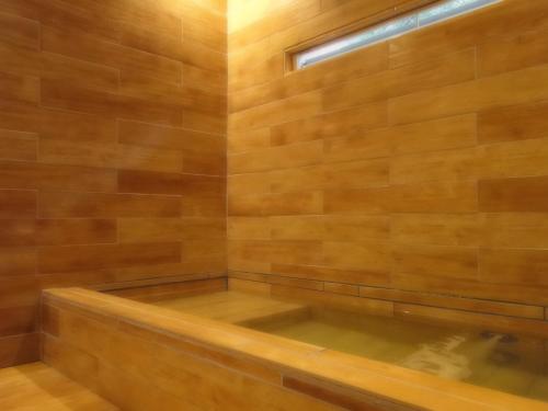 a sauna with a tub in a wooden wall at ノマの森 Nomanomori B&B in Chino