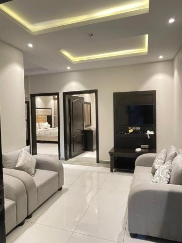 a living room with two couches and a flat screen tv at Best night hotel in Taif
