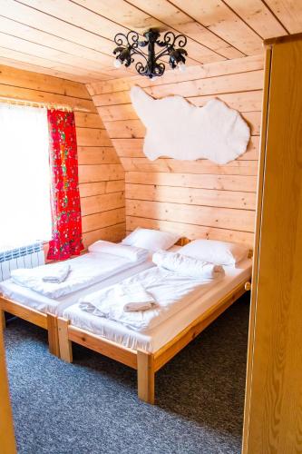 a bedroom with a bed in a wooden room at Willa pod Granią in Białka Tatrzańska