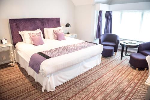 a hotel room with a large bed with pink pillows at The Casa Hotel, Sure Hotel Collection by Best Western in Yateley