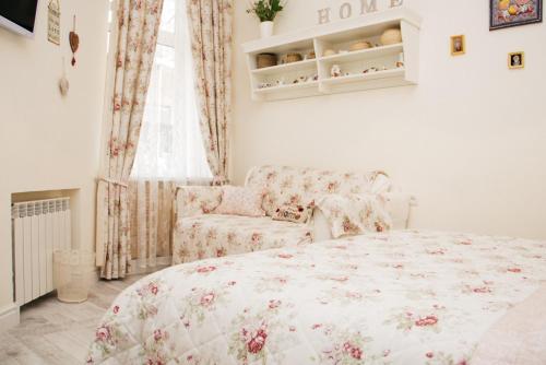 a bedroom with a bed and a couch and a window at Romantic apartment near Opera with Air-conditioning in Lviv