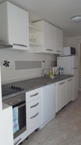 a kitchen with white appliances and white cabinets at Apartments Vucetic in Hvar