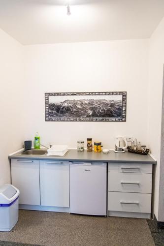 a kitchen with white cabinets and a counter top at Willa pod Granią in Białka Tatrzańska