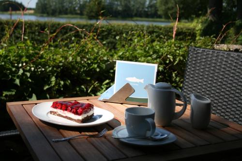 ein Stück Kuchen auf einem Tisch mit einem Teller Essen in der Unterkunft Fischerwiege am Passader See in Passade