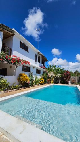 eine Villa mit einem Swimmingpool vor einem Haus in der Unterkunft Iaia apartments in Jambiani