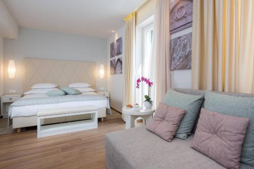 a bedroom with a bed and a couch at Balatura The Fine Bed&Breakfast Split in Split