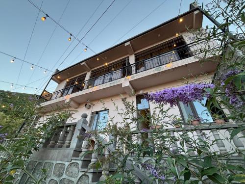 a building with a balcony with purple flowers at TIGRAN Hotel by Black & Gold in Goris