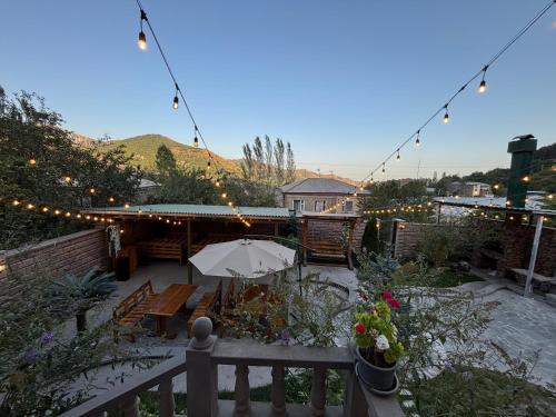 a patio with a table and an umbrella and lights at TIGRAN Hotel by Black & Gold in Goris