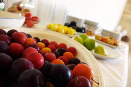 a table topped with bowls of fruit on plates at Masseria Carignani in Tuglie