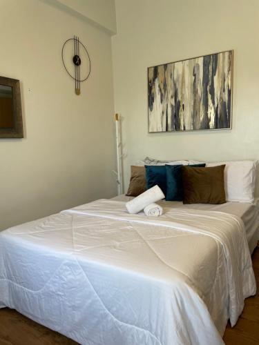 a bedroom with a large white bed in a room at Family Suites at the Amani Grand Residences - Mactan Airport in Pusok