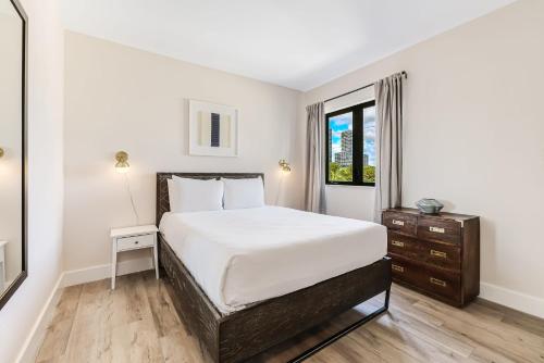 a white bedroom with a bed and a window at Roami at The Palace in Miami