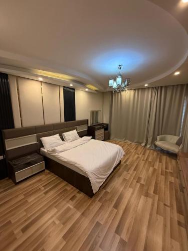 ein Schlafzimmer mit großem Bett und Holzboden in der Unterkunft فيلا مع حمام سباحه وجاردن 0306-888-0106 in Kairo